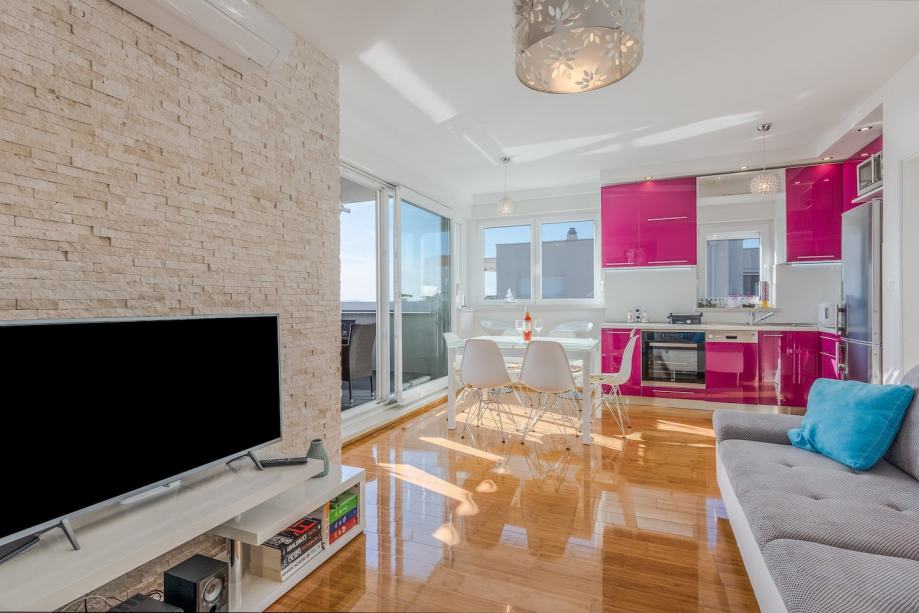 Obývací část s výhledem do růžové kuchyně.