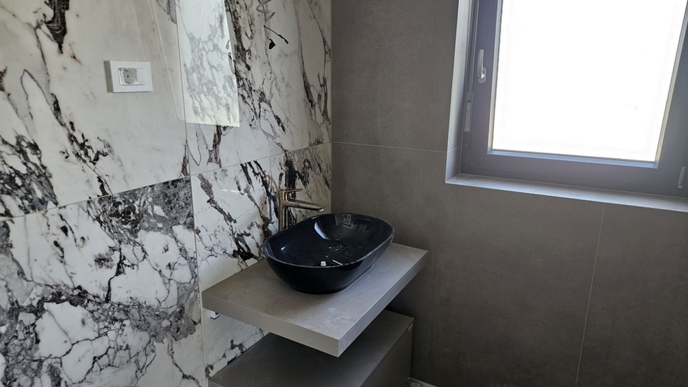 Moderní koupelna s mramorovými deskami na stěně.