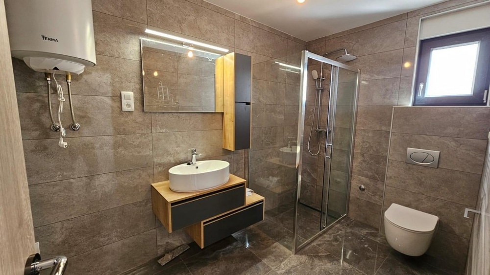 Koupelna s vysoce kvalitními obklady.