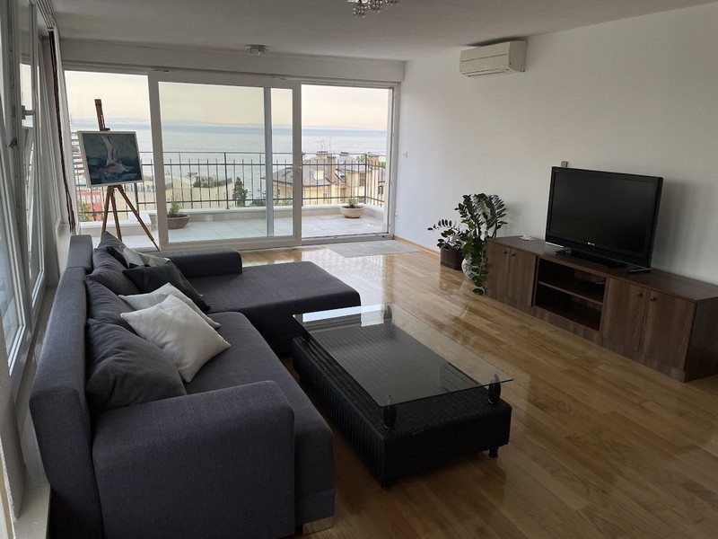 Obývací pokoj s výhledem na terasu a moře.