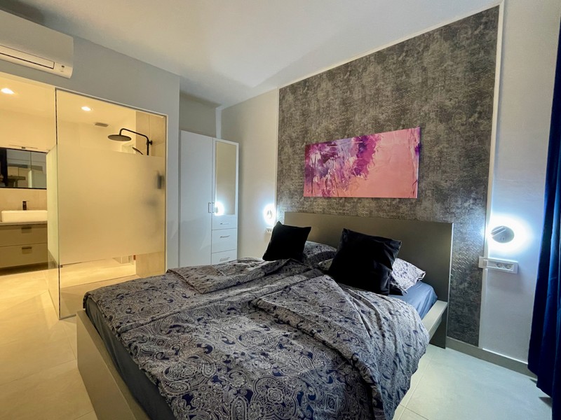 Vnitřní pohled na koupelnu se skleněnou sprchovou zástěnou a pohled na světlý pokoj v bytě na prodej v Zadaru, Chorvatsko