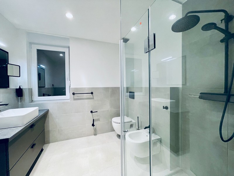 Letecký pohled na moderní žluté bytové domy s výhledem na zasněžené hory v regionu Zadar, Chorvatsko