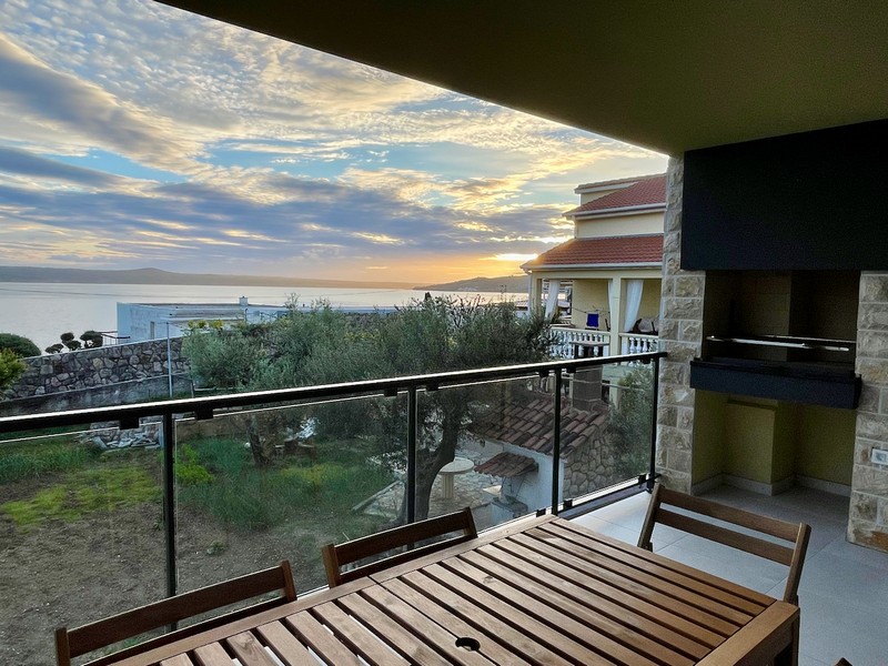 Večerní pohled na osvětlený obdélníkový bazén v apartmánovém komplexu na prodej v Zadaru, Chorvatsko