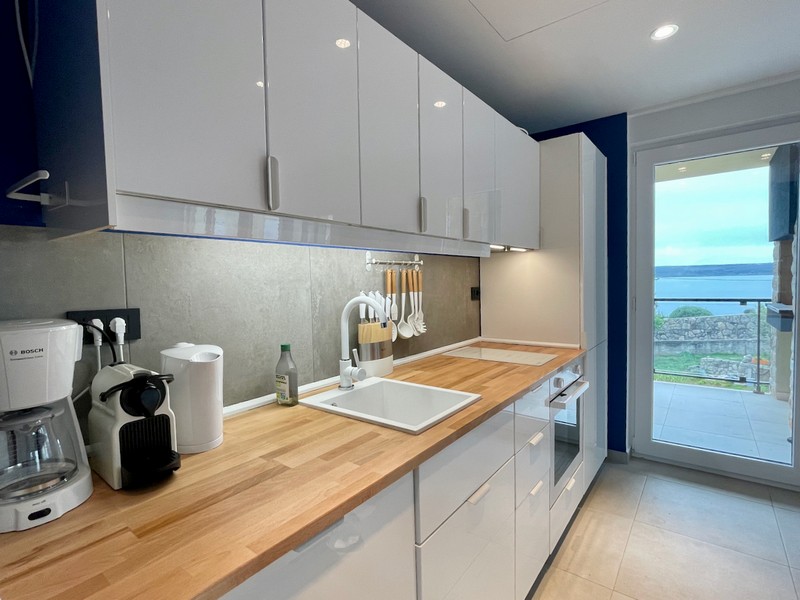 Boční pohled na moderní žluté obytné budovy s balkony a kamennými detaily na prodej v Zadaru, Chorvatsko