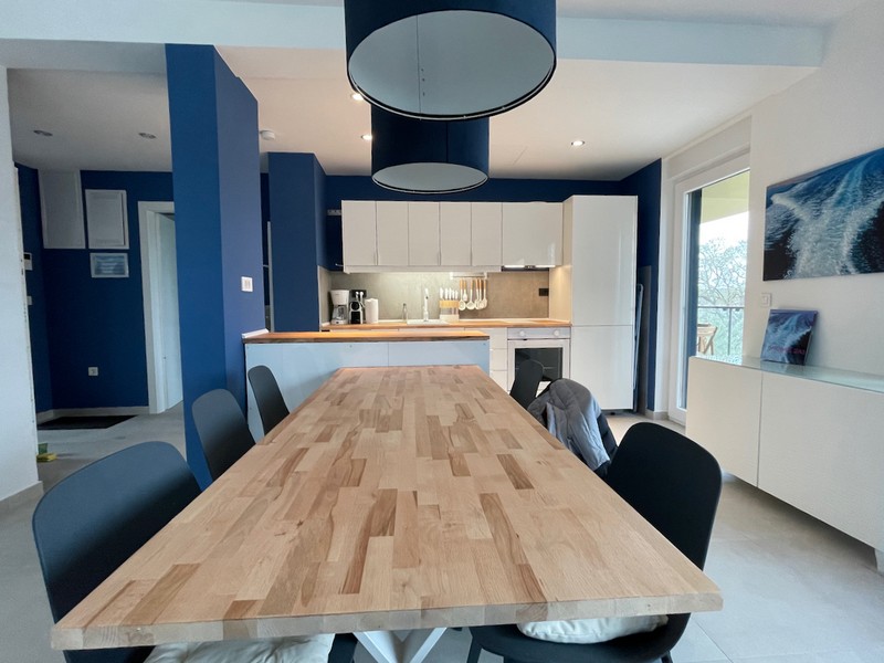 Prostorný nedokončený obývací pokoj s bíle natřenými stěnami a přípravou pro instalaci kuchyně v bytě v Zadaru v Chorvatsku