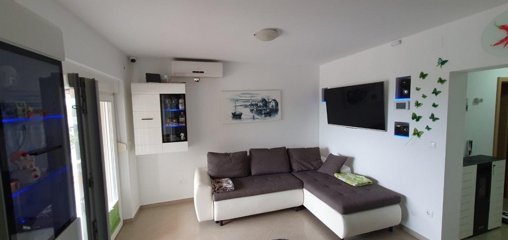 Útulný, zařízený obývací pokoj s pohovkou a klimatizací.