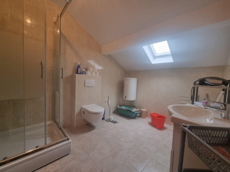 Prostorná koupelna se sprchovým koutem.