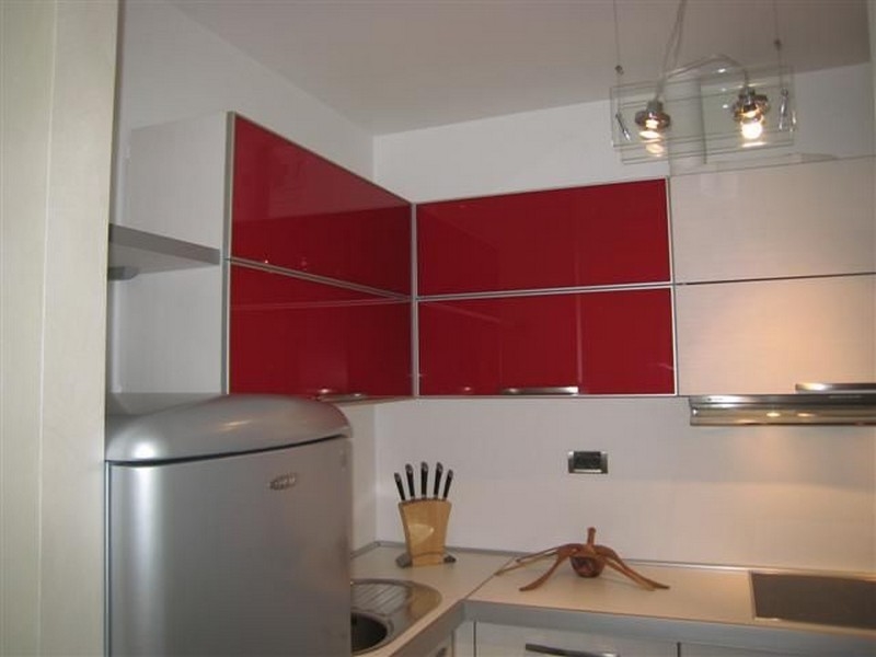 Moderní kuchyně s červenými prvky.