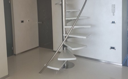 Bílé točité schodiště, které vede do čtvrtého patra.