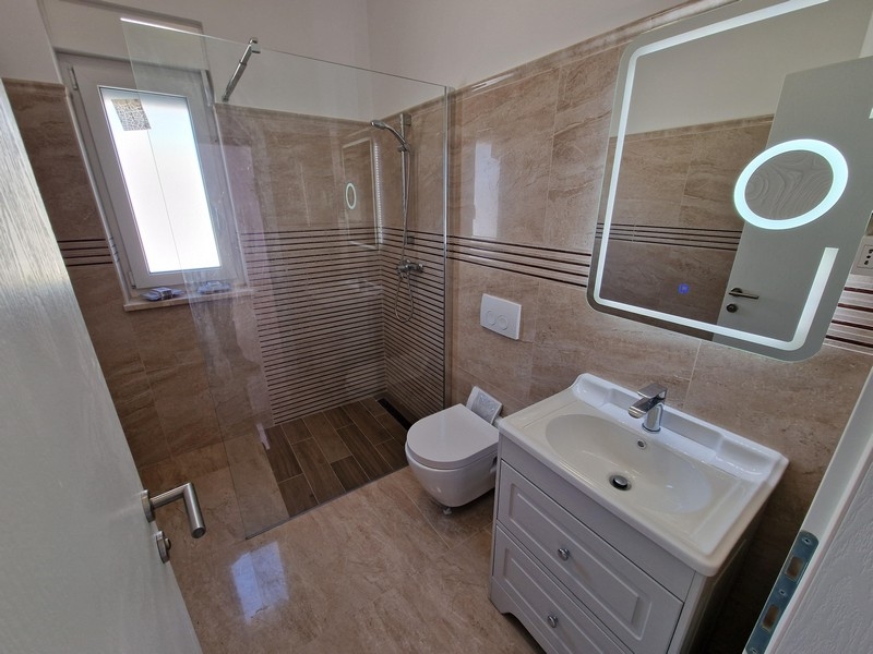 Koupelna se sprchovým koutem.