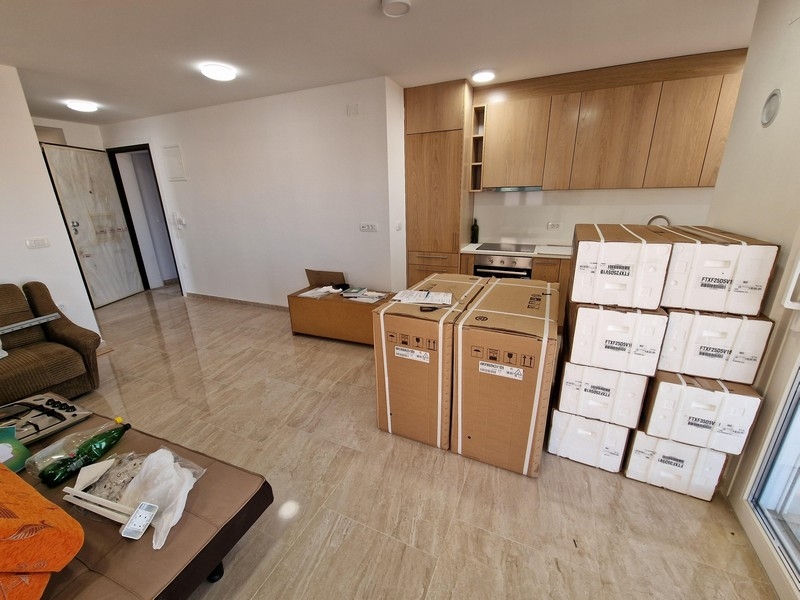 Moderní obývací prostor s otevřeným konceptem a kuchyní.