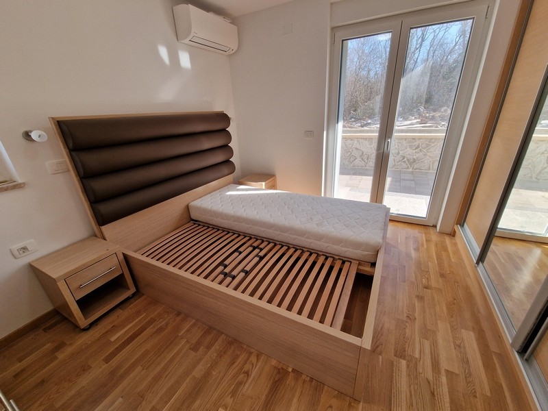 Manželská postel v ložnici a výhled na terasu.