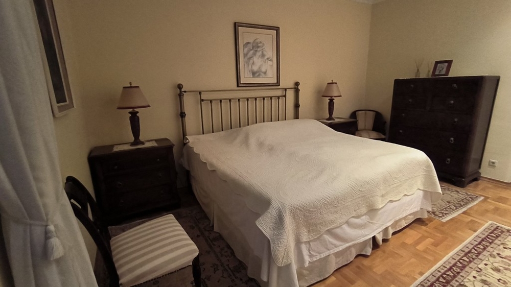 Větší ložnice s manželskou postelí.