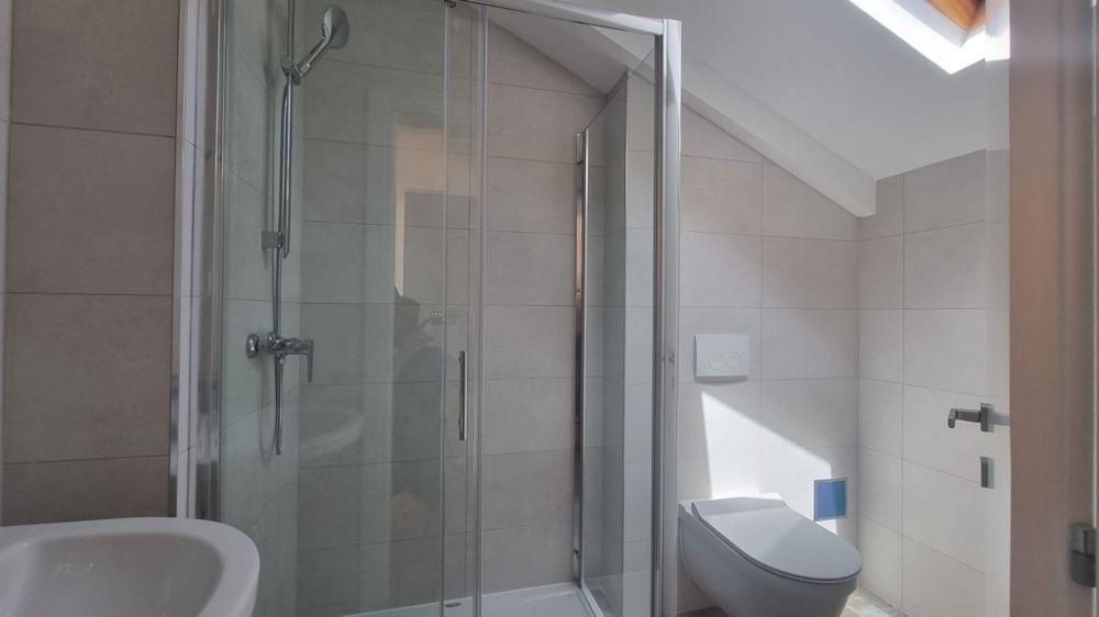 Koupelna se sprchovým koutem.