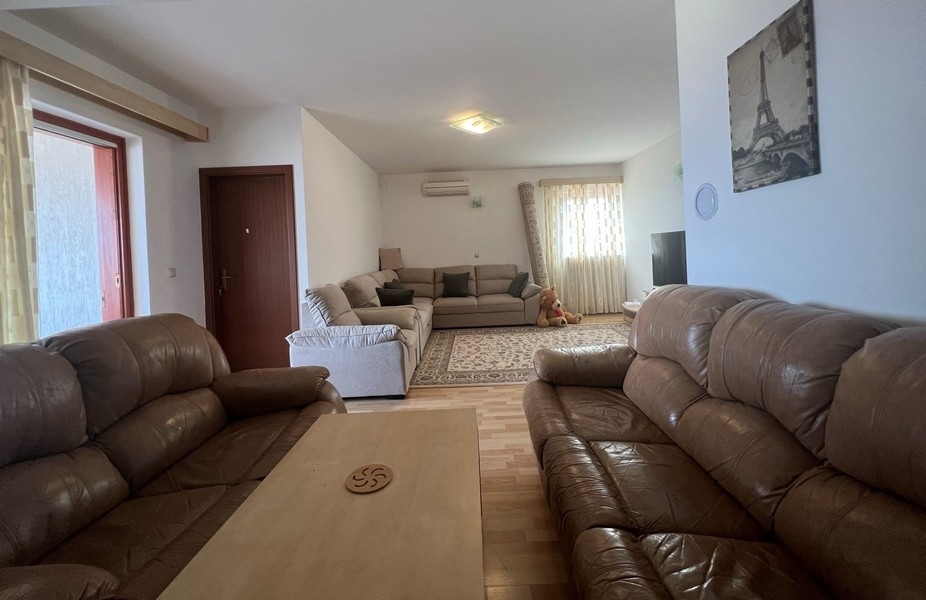 Obývací pokoj se třemi pohovkami.