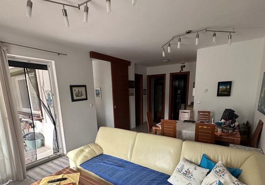 Zařízený obývací pokoj a výhled na jídelní stůl.