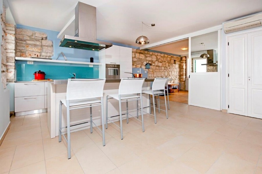 Moderní kuchyně s tyrkysovým kuchyňským koutem.