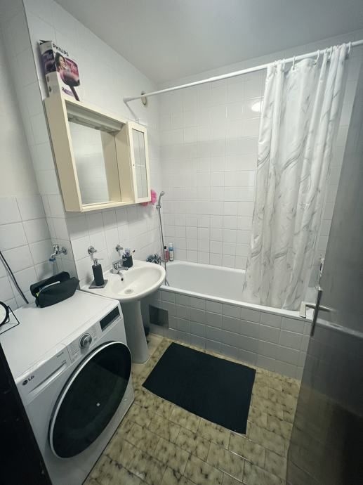 Koupelna s pračkou a vanou.