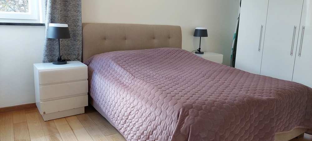 Ložnice s velkou manželskou postelí a minimalistickým designem v Opatiji