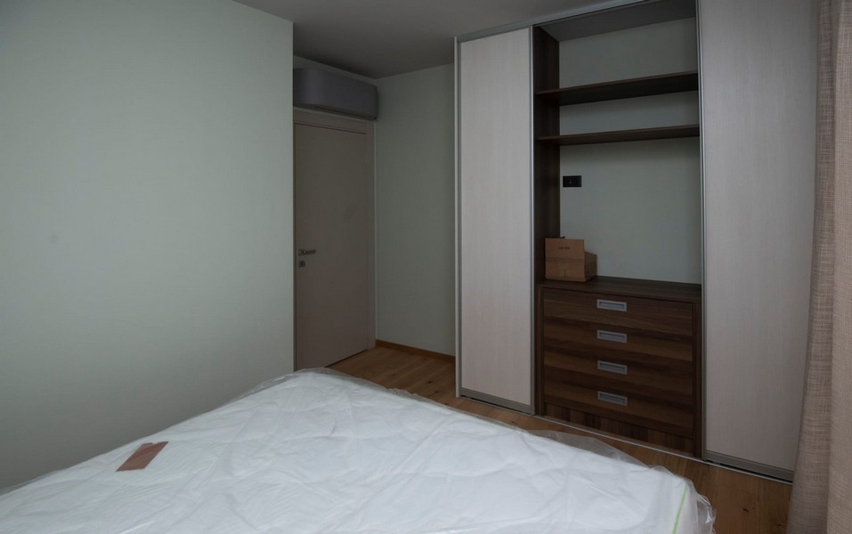 prostorná ložnice moderního bytu ve Splitu v Chorvatsku na prodej s vestavěnou skříní a dřevěnou podlahou.