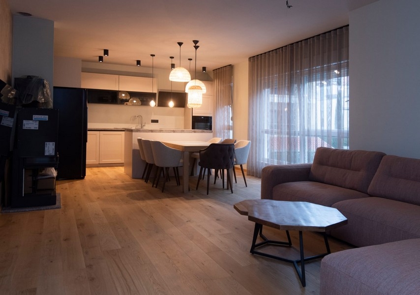 Elegantní a moderní obývací pokoj s průchodem do kuchyně v apartmánu ve Splitu v Chorvatsku, ideální pro zábavu.