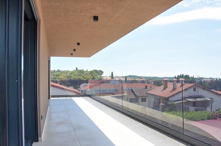 Krytý balkon penthouse na Istrii s výhledem na místní architekturu a moře.