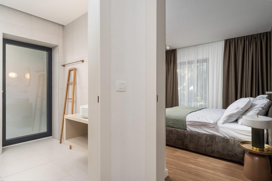 Útulná ložnice v luxusním apartmánu na Istrii s přímým přístupem do koupelny a moderním interiérem