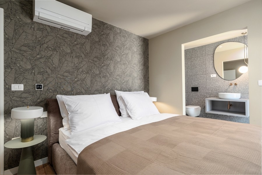 Ložnice v luxusním apartmánu na Istrii s designovou stěnou a moderním interiérem