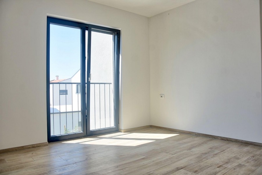 Světlá ložnice s balkonovými dveřmi a plovoucí podlahou, součást nabídky nemovitosti v Poreči