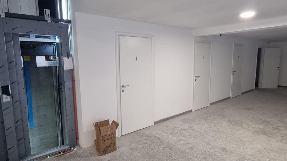 Chodba v chorvatské nemovitosti s bílými dveřmi a výtahem vlevo na obrázku.