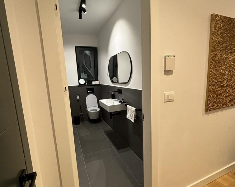 Moderní koupelna s šedými obklady a zrcadly, nemovitost na prodej v Rijece, Chorvatsko.