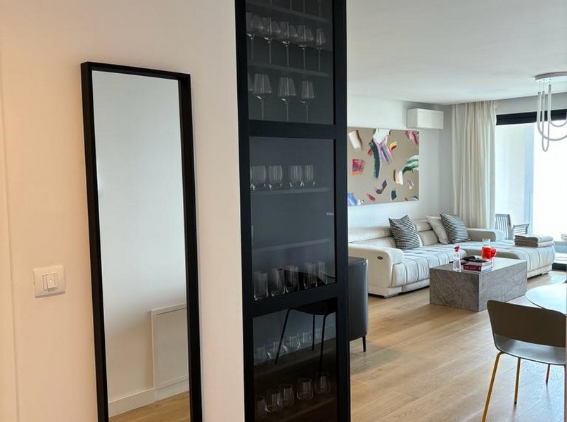 Elegantní stojan na víno vedle černých skleněných dveří, detail bytu na prodej v Rijece, Chorvatsko.