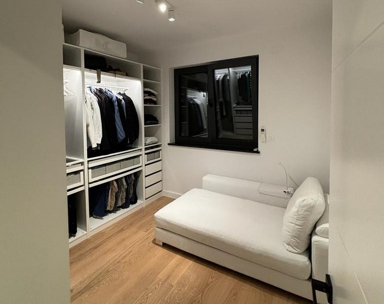 Kompaktní pokoj pro hosty s bílou rozkládací pohovkou a vestavěnou skříní, nemovitost v Rijece, Chorvatsko.