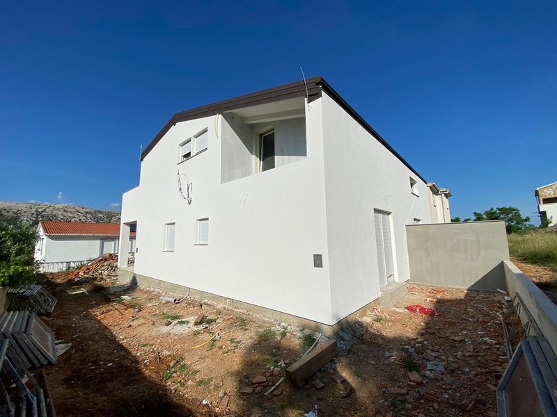 Interiér bytu na prodej v chorvatském Pagu v hrubé stavbě s pohledovým zdivem a stavebním nářadím