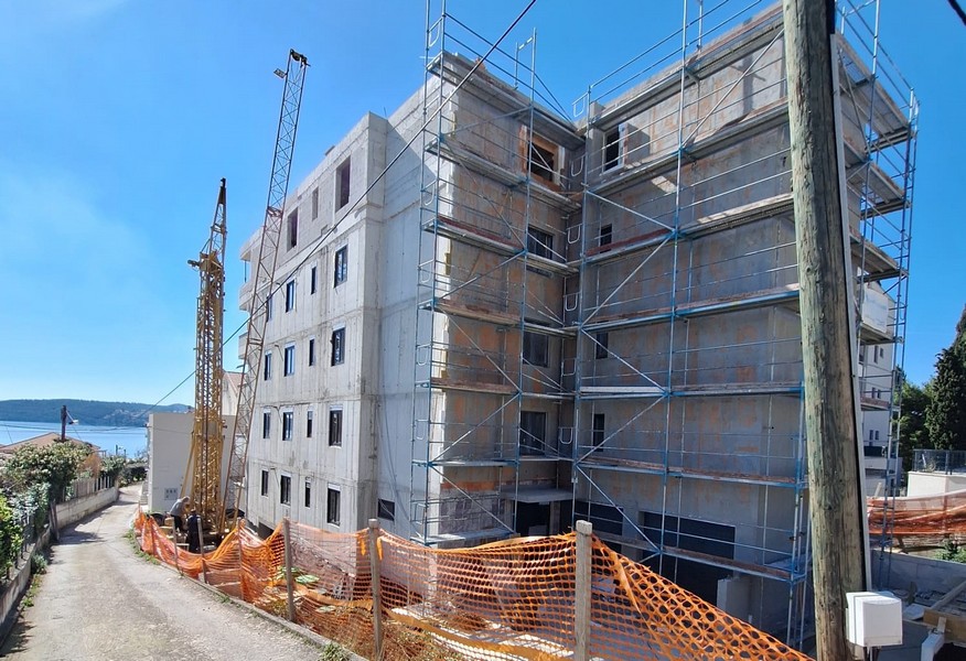 Zadní pohled na rozestavěný činžovní dům s lešením a jeřábem v Chorvatsku, který nabízí Panorama Scouting