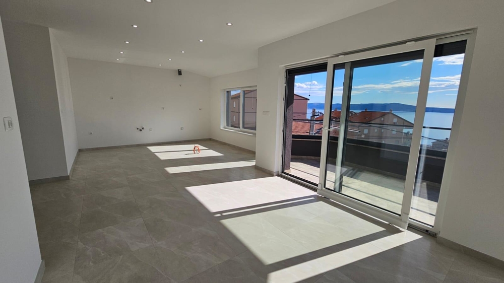 Slunný obývací pokoj bytu k prodeji v Crikvenici s přístupem na balkon a výhledem na pobřeží