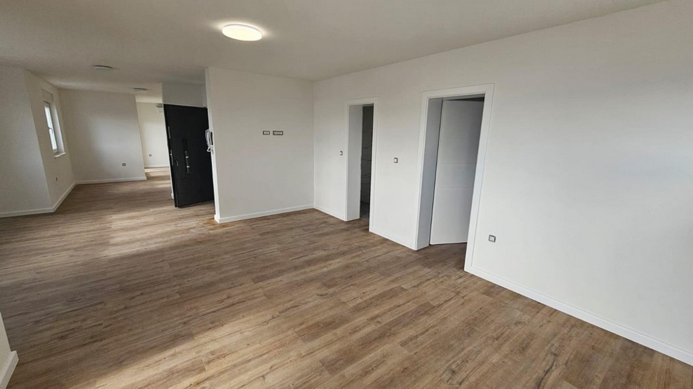 Prostorný obývací prostor bytu na prodej v Crikvenici, Chorvatsko, s dřevěnými podlahami a bílými stěnami