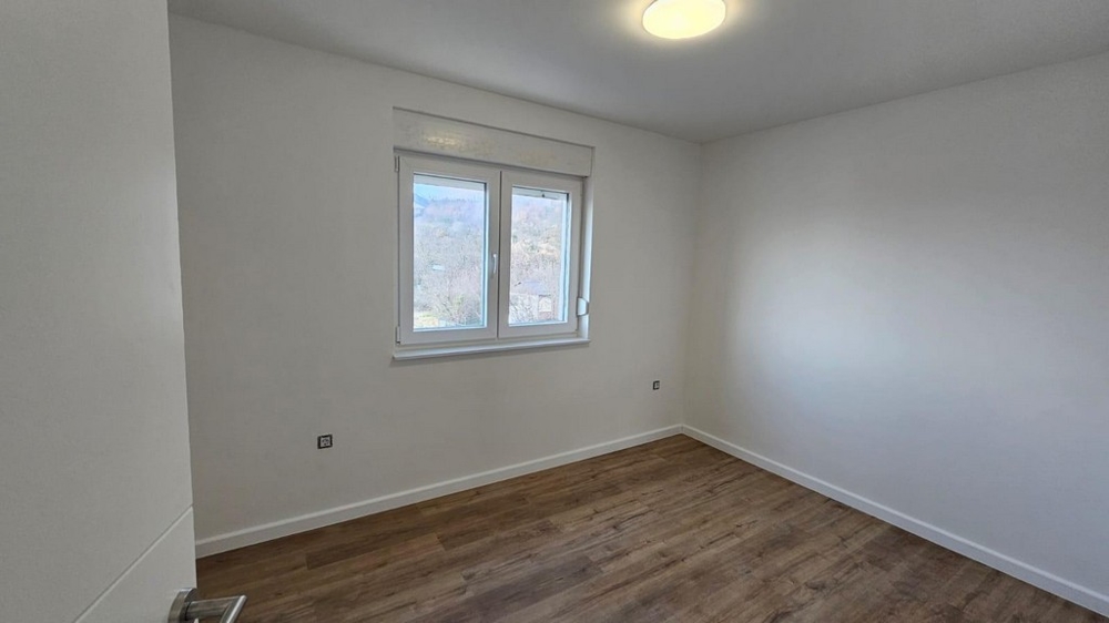 Prázdná ložnice v bytě na prodej v Crikvenici, Kvarnerský záliv, s dřevěnými podlahami a bílými stěnami