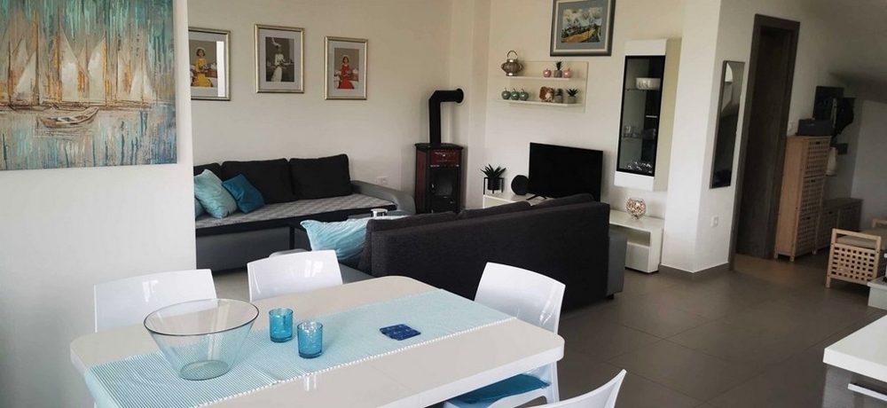 Prostorný otevřený obývací pokoj a jídelna v apartmánu v Tisno, Chorvatsko na prodej s moderním nábytkem.