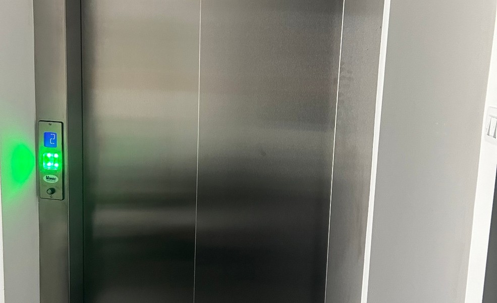 Vnitřní záběr moderního výtahu s dveřmi z nerezové oceli v činžovním domě v Rijece.