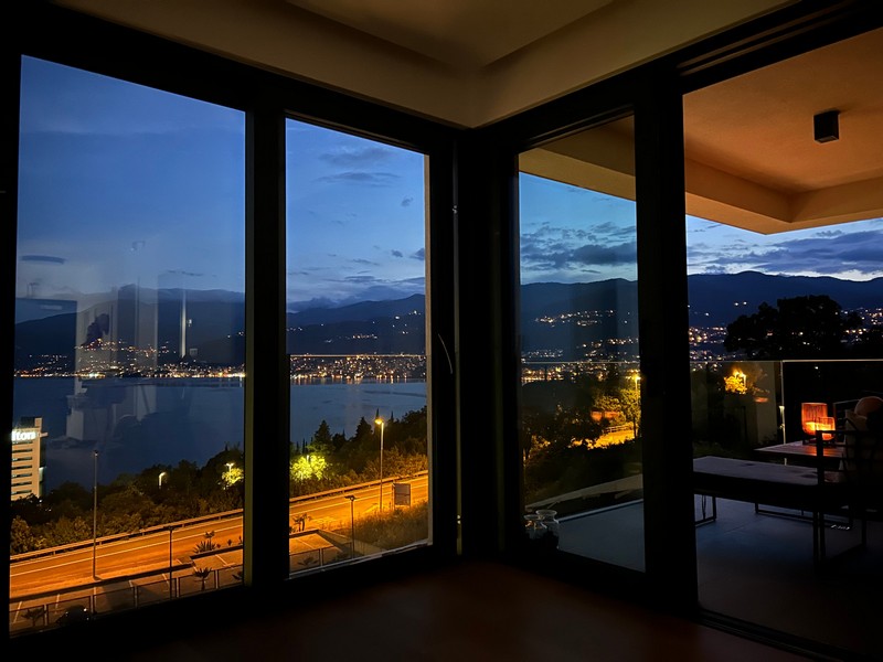 Noční pohled z balkonu bytu v Rijece s výhledem na osvětlené pobřeží.