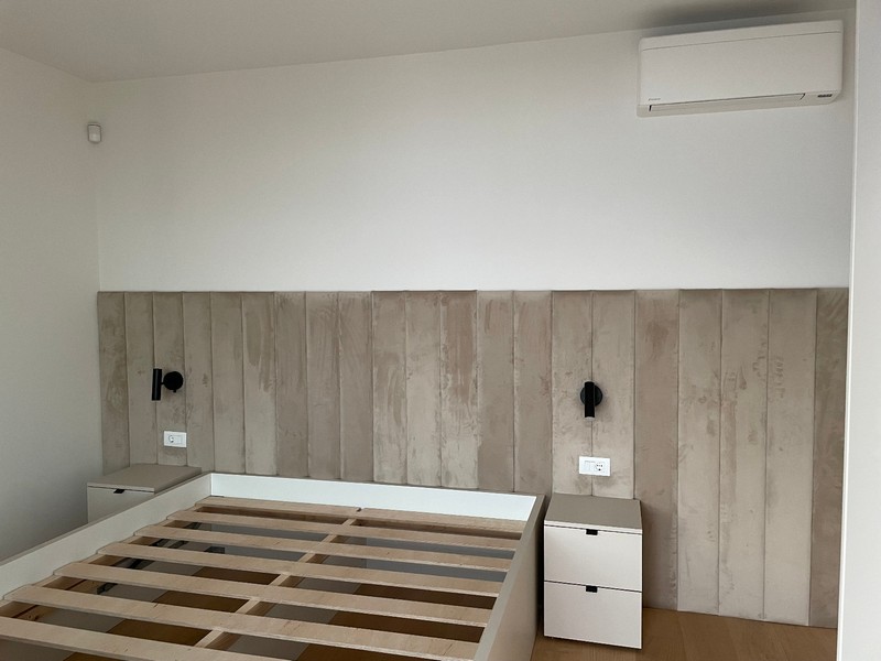 Minimalistická ložnice s vestavěnou postelí a klimatizací v apartmánu v Rijece.