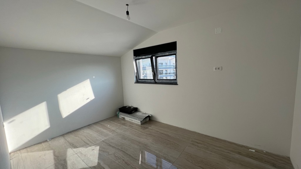 Minimalisticky řešený obývací pokoj se světlou dlažbou, vhodný do moderních nemovitostí v Chorvatsku.