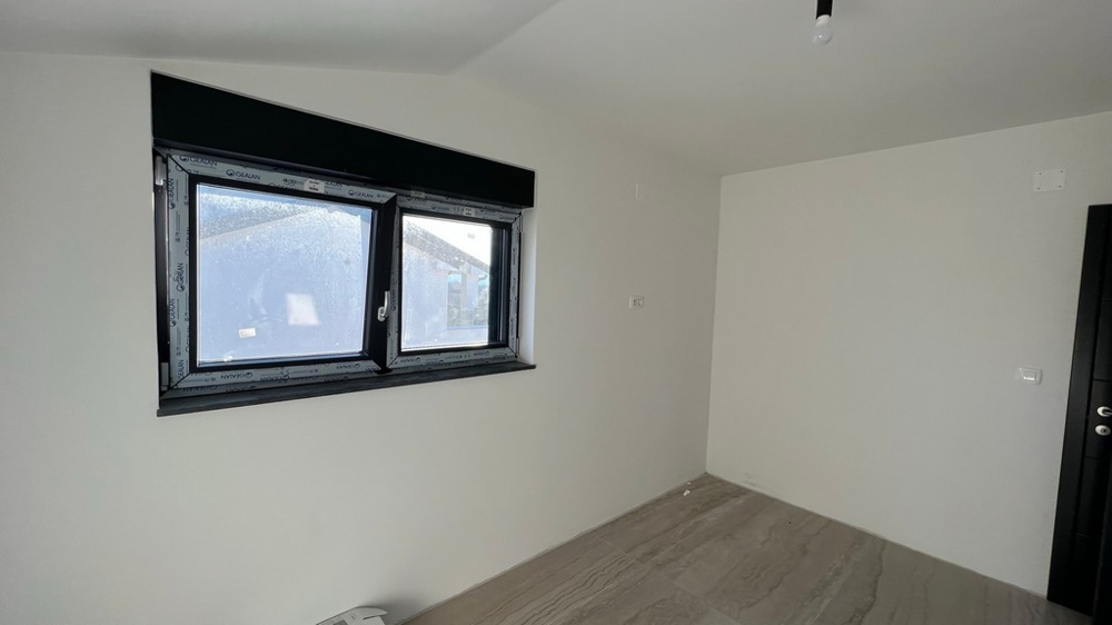 Jednoduchý pokoj s výhledem z okna, potenciální ložnice v apartmánu v Chorvatsku