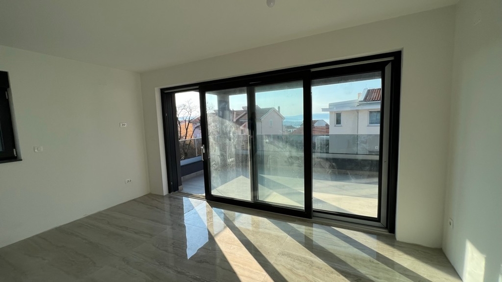 Světlý obývací prostor s celoplošnými okny zapadá do moderního konceptu nemovitosti na ostrově Krk.