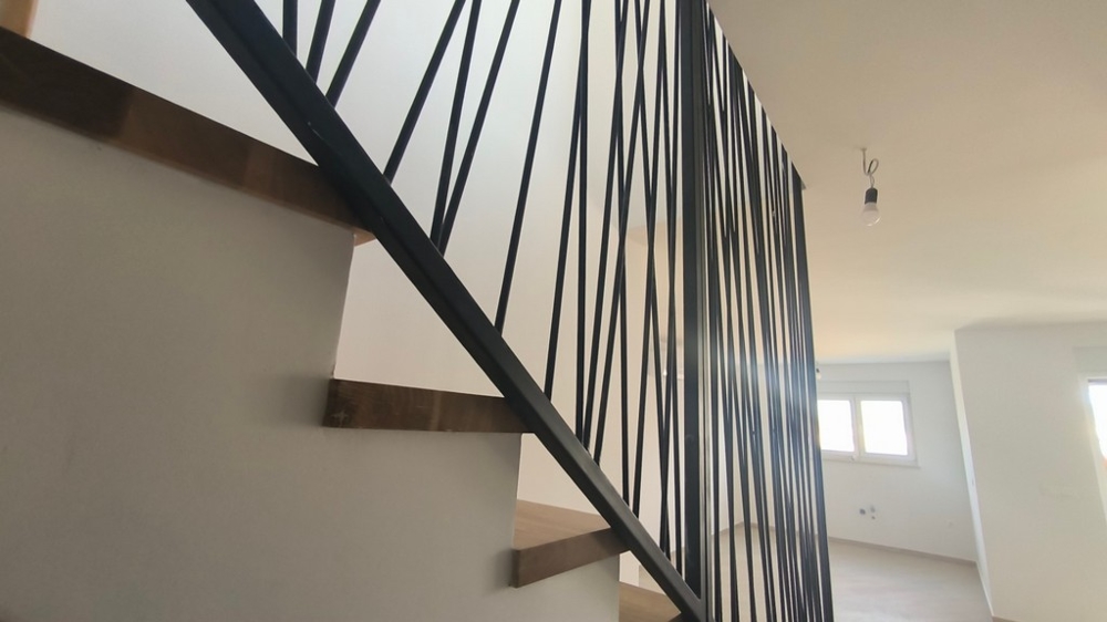 Interiérové ​​schodiště s moderním zábradlím v penthouse, nemovitost v Chorvatsku v Šimuni, které kombinuje eleganci a design.