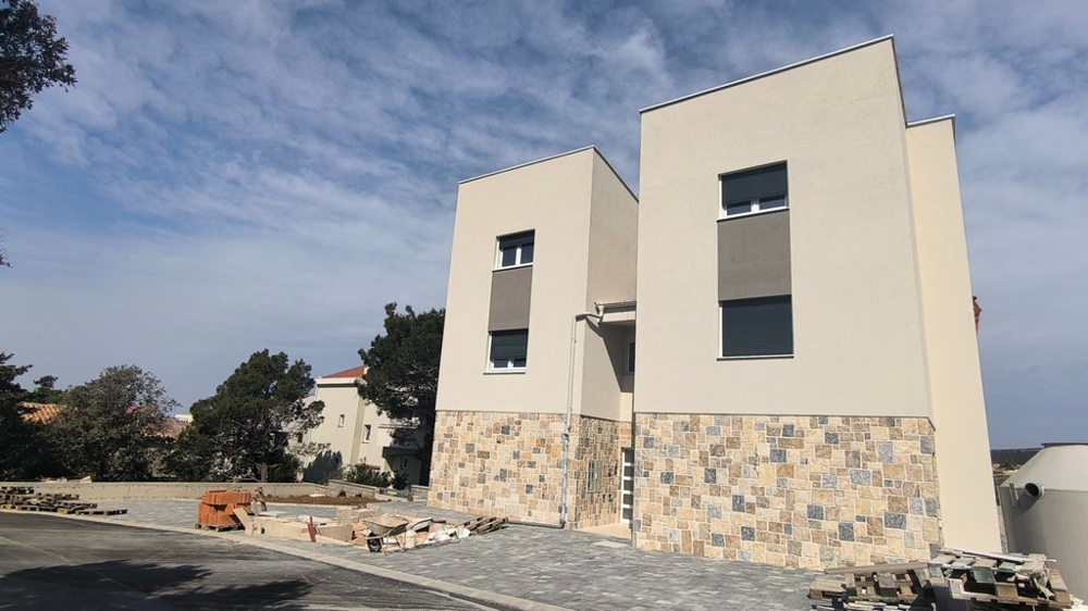 Vnější pohled na dvě nově postavené budovy, nemovitost v Chorvatsku v Šimuni s viditelným vstupním prostorem.