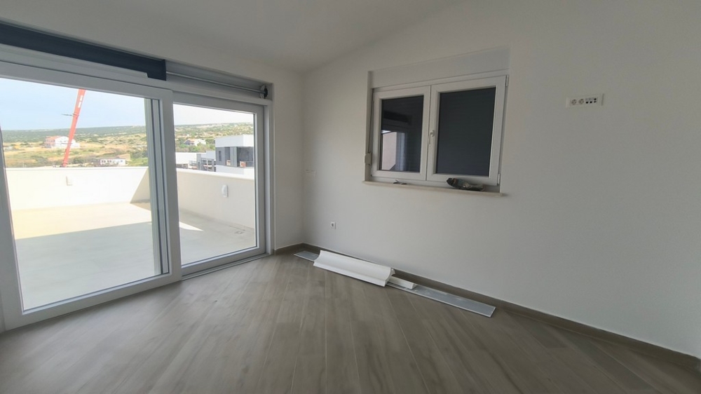 Světlý, moderní obývací pokoj penthouse, nemovitost v Chorvatsku v Šimuni s přístupem na terasu a výhledem na moře.