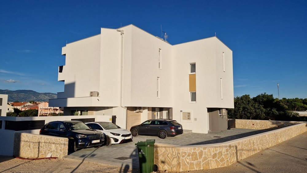 Boční pohled na moderní bytový dům s parkovacími místy v Novalji, ostrov Pag, Real Estate Chorvatsko