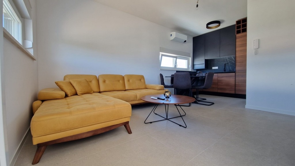 Interiér bytu v Novalji, ostrov Pag, s moderním nábytkem a žlutou pohovkou, chorvatská nemovitost
